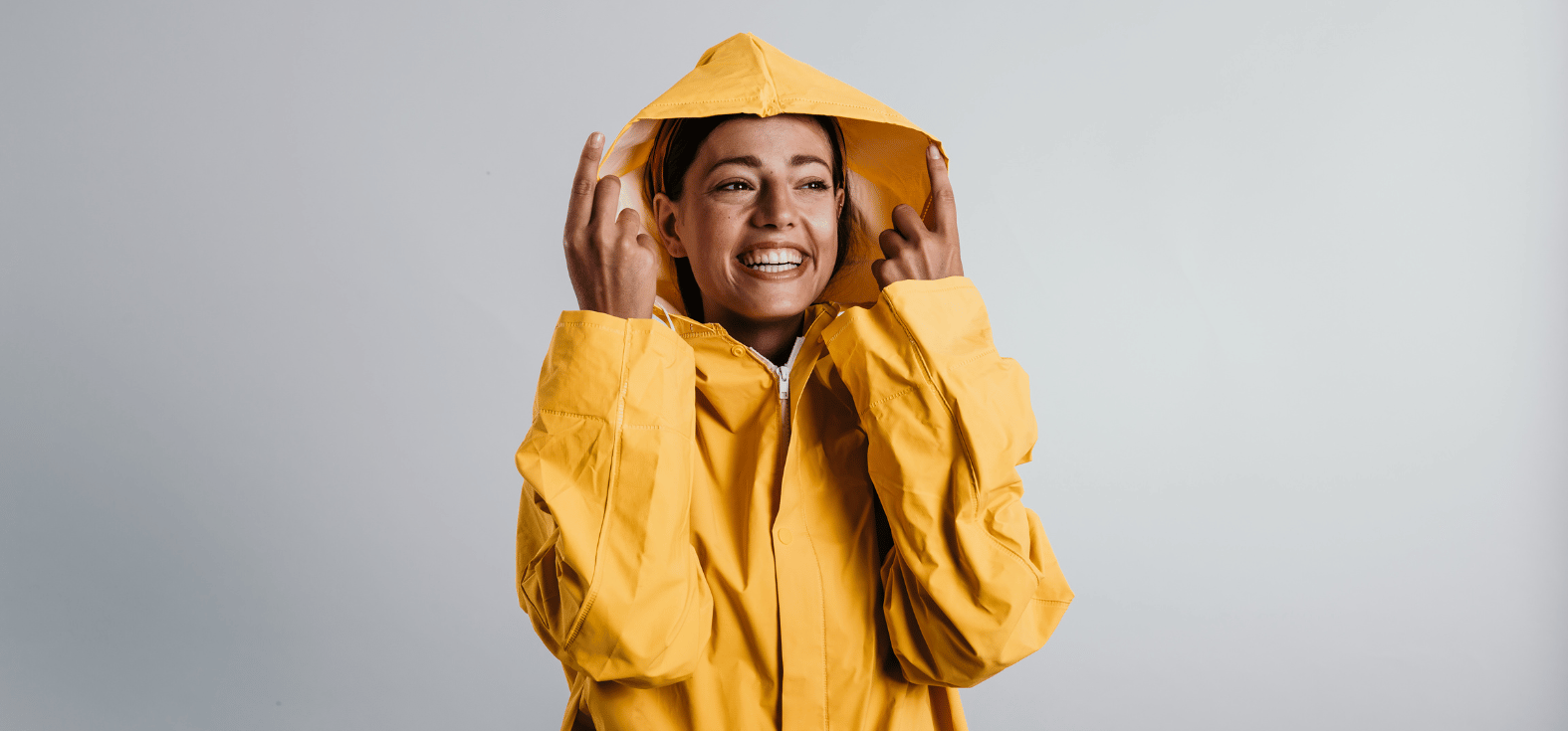 Young women using a durable reusable raincoat with long-lasting rain protection.